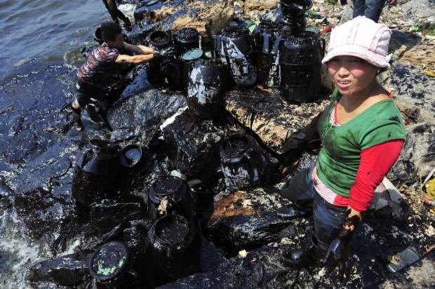 fishermen-clean-up-oil-near-a-major-northern-chinese-port-after-a-pipeline-blast-leaked-more-than-1600-tons-of-heavy-crude-into-the-sea-in-july-2010