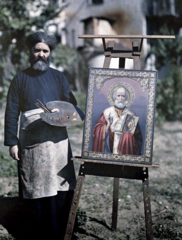 Αγιογράφος στο Άγιο Όρος στέκεται δίπλα σε μία εικόνα του Αγίου Νικολάου