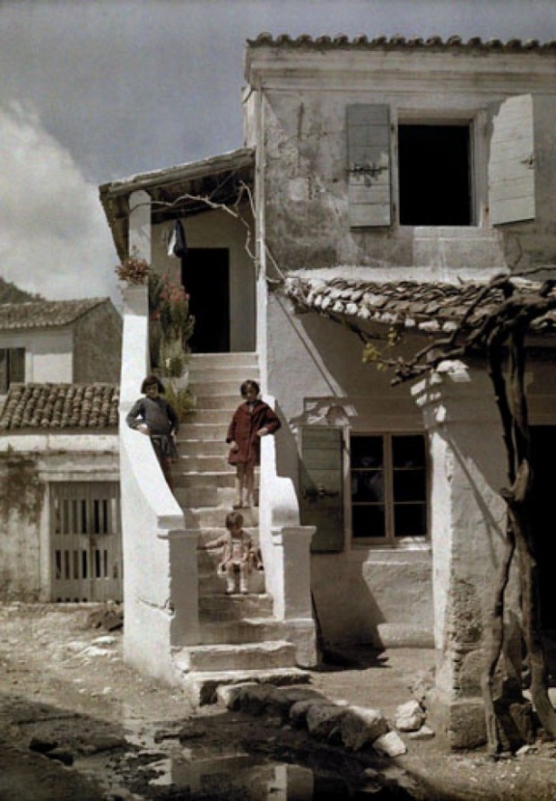 Κορίτσια στέκονται σε σκάλα σπιτιού που βρίσκεται σε κερκυραϊκό ψαροχώρι