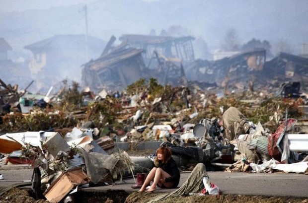 Μια γυναίκα κάθεται ανάμεσα στα συντρίμμια που προκάλεσαν ο σεισμός και το τσουνάμι στο Natori, της Βόρειας Ιαπωνίας, τον Μάρτιο του 2011