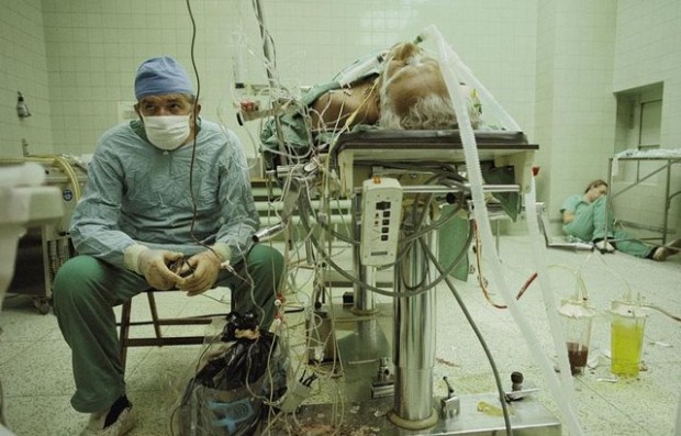  Χειρουργός καρδιάς μετά από (επιτυχημένη) μεταμόσχευση καρδιάς που διήρκεσε 23 ώρες. Η βοηθός του εξαντλημένη κοιμάται στη γωνία .