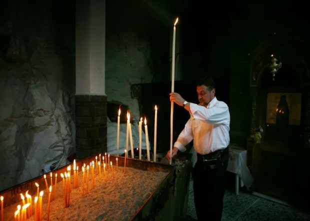 Ανάβοντας κερί στο Ιερό Αγίασμα της Αγίας Μεγαλομάρτυρος Παρασκευής στα Τέμπη.