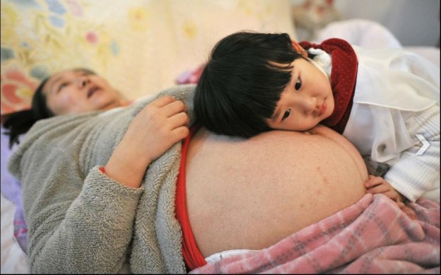 Η πρώτη Κινεζούλα που θα έχει αδελφό. Η Li Yan αφήνει την κόρη της να ξαπλώσει πάνω στην κοιλιά της, λίγο πριν γεννήσει ένα υγιέστατο αγοράκι. Η οικογένεια της Li Yan, είναι η πρώτη στη Κίνα που πήρε επίσημη άδεια να αποκτήσει και δεύτερο παιδί και σύμφωνα με κυβερνητικές πηγές, εκατομμύρια οικογένειες μέχρι το τέλος του χρόνου θα αποκτήσουν το ίδιο δικαίωμα, θέτοντας και επισήμως τέλος στην πολιτική του ενός παιδιού.Reuters Πηγή:kathimerini.gr- ΑΙΜΙΛΙΑ ΚΑΛΟΓΕΡΑΚΗ