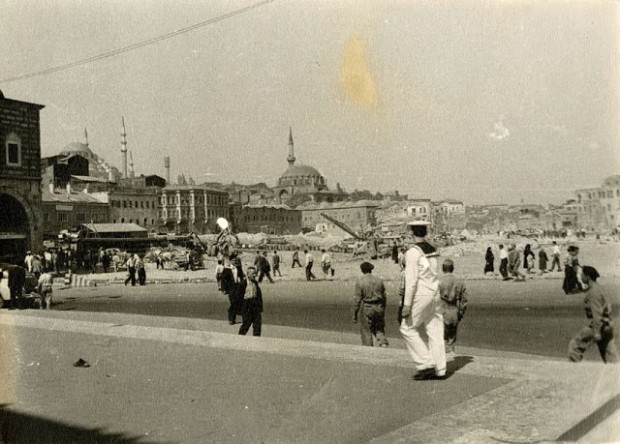 Ένα ναυτάκι ντυμένο στα λευκά κυριαρχεί στην φωτογραφία. Στο κέντρο της φωτογραφίας το τέμενος Ρουστέμ Πασά, δεξιότερα το Σουλειμανιγιέ και η Αιγυπτιακή Αγορά 