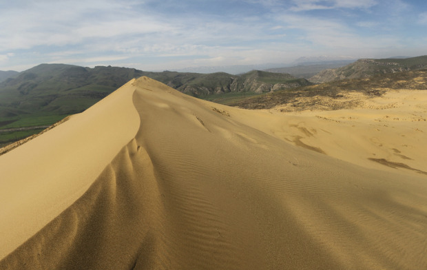 Ο αμμόλοφος Σαρικούμ στο Νταγκεστάν βρίσκεται κοντά στην πρωτεύουσα Μαχατσκάλα. Ρώσοι επιστήμονες θεωρούν τον μεγαλύτερο αμμόλοφο της Ευρασίας ως αμμόλοφο απολίθωμα, που σημαίνει ότι δεν έχει υποστεί αλλαγές, όπως οι γεωλογικές δομές γύρω από αυτόν. Το ψηλότερο σημείο του αμμόλοφου είναι 250 μέτρα, ενώ αποτελείται από ψιλή χρυσή άμμο και μοιάζει με μικρογραφία ασιατικής ερήμου. Φωτο:Lori / Legion Media