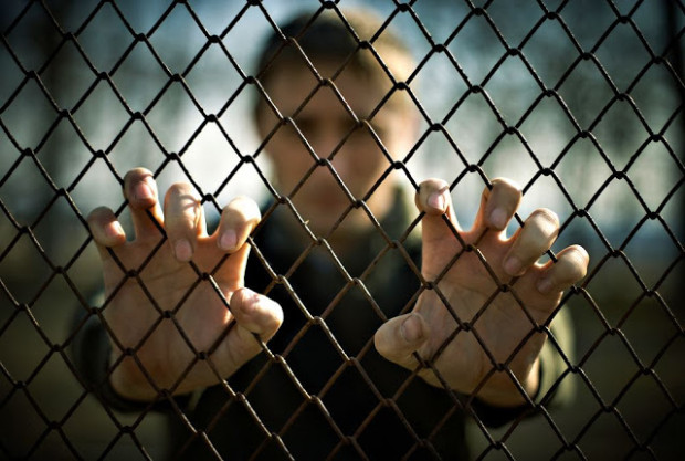shutterstock_74741107-man-in-prison-hands-on-fence edited