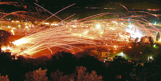 Rockets streak through the sky during Greek Orthodox Easter celebrations on the Greek island of Chios April 8, 2007. Thousands of home-made rockets are fired on Easter Sunday every year by locals from two rival churches in the Vrontados area in a centuries-old tradition. The two sides, who have been preparing tens of thousands of rockets for months, launch rockets aimed at the opposing church's bell tower. REUTERS/Vassilis Tryantafylou (GREECE)