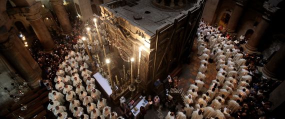 TOPSHOT - Roman Catholic clergymen hold candles as they circle the Aedicula during the Holy Thursday (Maundy Thursday) mass at the Church of the Holy Sepulchre in Jerusalem's Old City on March 24, 2016. / AFP / GALI TIBBON        (Photo credit should read GALI TIBBON/AFP/Getty Images)