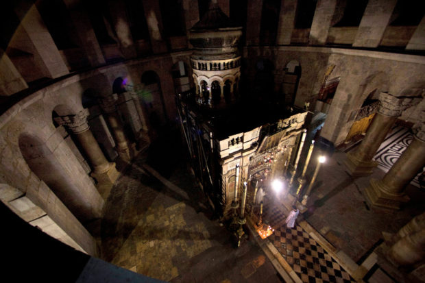 FILE - In this Friday, May 18, 2012 file photo, Greek Orthodox priests hold liturgy outside the tomb of Jesus in the Holy Sepulcher church in Jerusalem. A team of experts is set to begin a historic renovation at Jesus’ Tomb in Jerusalem’s Old City, overcoming longstanding religious rivalries to carry out the first repairs at the site in over 200 years. (AP Photo/Dusan Vranic, File)